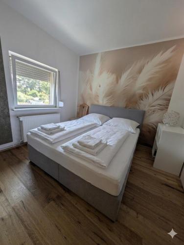 a bedroom with a large bed with a feather mural on the wall at Haus (1. Etage+DG) mit Garten in Passendorf
