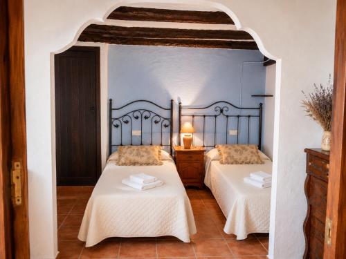 a bedroom with two beds with white sheets at Cal Gironell in Santa María de Meyá