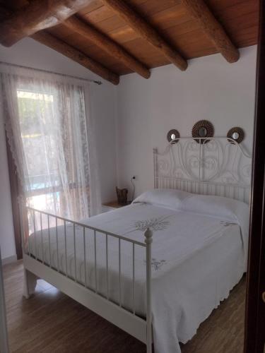 a bedroom with a white bed and a window at KaraA'mare in San Teodoro