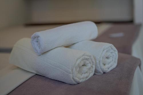 two rolls of white towels sitting on a table at Pousada Taquarí Guaibim in Valença
