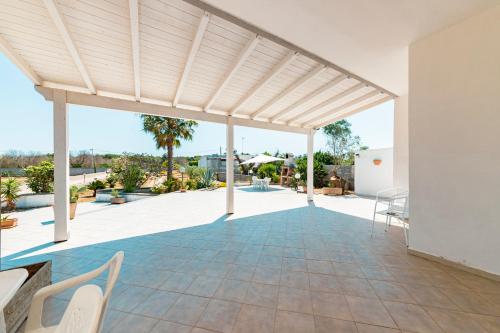 an outdoor patio with a wooden pergola at Baglivi's Flat in Torre Specchia Ruggeri