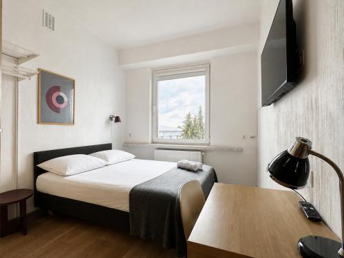 a bedroom with a bed and a table and a window at Pokoje & Bistro Mielec in Mielec