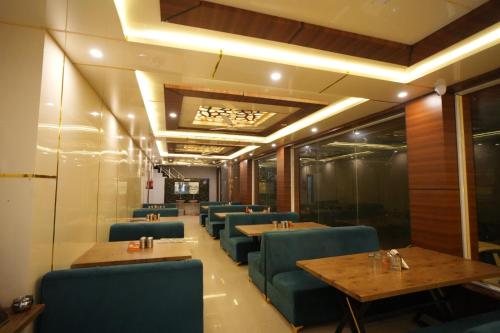 a restaurant with wooden tables and blue chairs at The Great Hill View Hotel in Phata