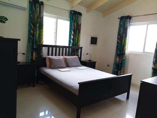 a bedroom with a bed in a room with windows at Caribbean Court E1 in Kralendijk
