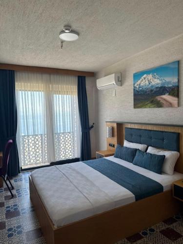 a bedroom with a large bed in a room at Grand Rimedya Hotel in Karabağ