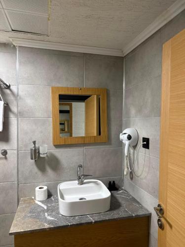 a bathroom with a sink and a mirror at Grand Rimedya Hotel in Karabağ