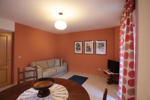 a living room with a couch and a table at Beauregard apartment in Aosta