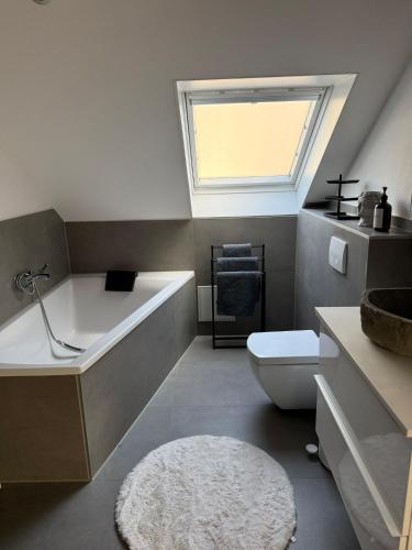 a bathroom with a tub and a toilet and a window at Ferienwohnung Monteurwohnung in Lüdenscheid