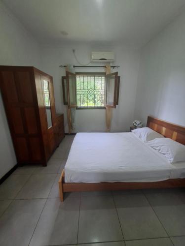 a bedroom with a white bed and a window at Quinta de 4 Pilares in Canavial