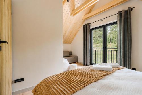 a bedroom with a bed and a large window at SenWood House in Zubrzyca Dolna