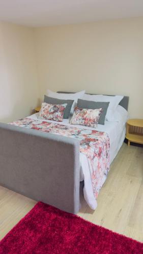 a bedroom with a bed with a red rug at Casa dos Devezas in São Gregório