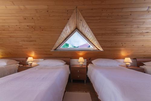 a bedroom with two beds with a window in it at B&B Na Kluk in Idrija