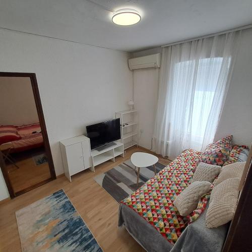 a living room with a couch and a television at E & E apartment in Koper