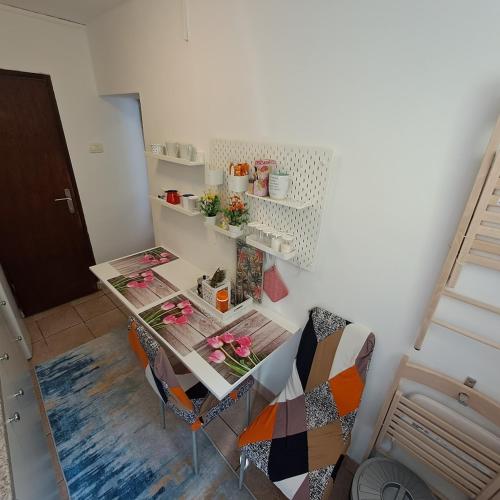 a room with a table and chairs with flowers on it at E & E apartment in Koper