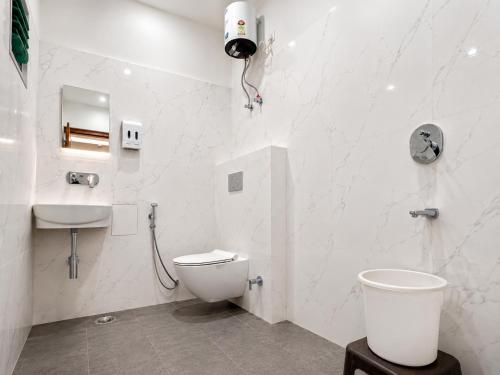 a white bathroom with a toilet and a sink at Hotel Devi Ram Atithi Bhawan Near Banke Bihari Mandir in Vrindāvan