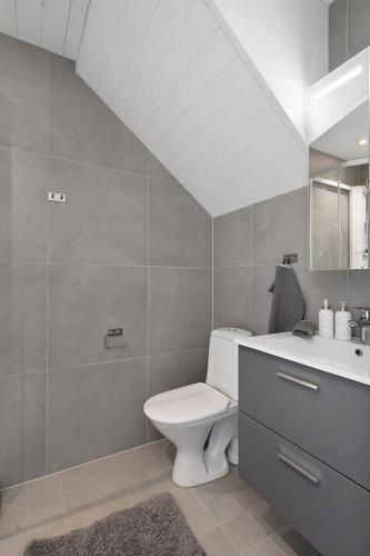 a bathroom with a white toilet and a sink at Sommerbolig i byen in Kristiansand