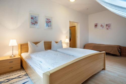 a bedroom with a large bed with white sheets at Herrenhaus Carolinenhof in Groß Plasten