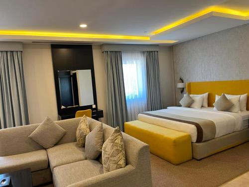 a hotel room with a bed and a couch at DAM hodoo دام الهــــــــدوء in Al Khobar