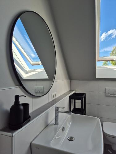 a bathroom with a mirror and a sink at Rebenmeer Wohnung in Roschbach in Roschbach