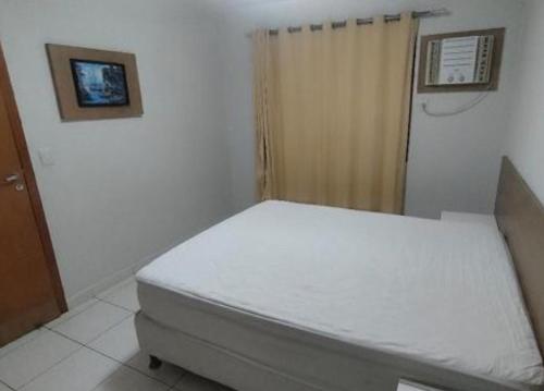 a small bedroom with a bed in a room at Suite no Boulevard suite hotel in Caldas Novas