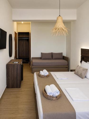 a hotel room with two beds and a couch at Este Luxury Apartments in Kriopigi