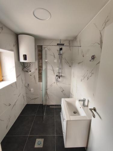 a white bathroom with a shower and a sink at Roman Paradise Villa with Pool in Koper