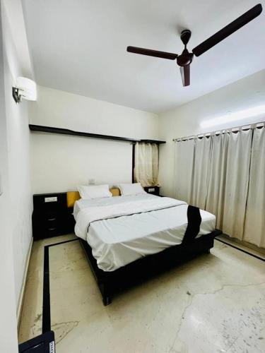 a bedroom with a bed and a ceiling fan at U K I Guest House in Bangalore