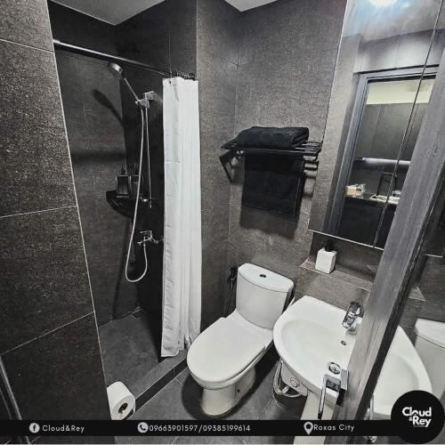 a bathroom with a toilet and a shower and a sink at Cloud&Rey Rentals in Roxas City