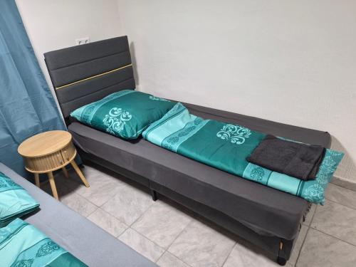 a bed with a green comforter and a table at Nektarioss in Kernen