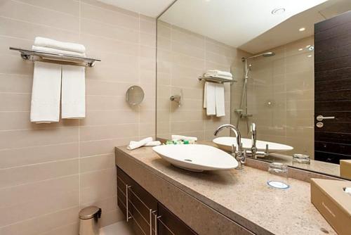a bathroom with a sink and a large mirror at Hôtel Souani ( Al Hoceima Bay) in Al Hoceïma