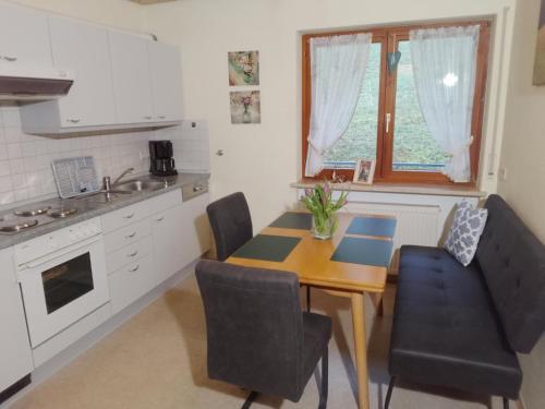 a kitchen with a table and chairs in a kitchen at Apartment in Hofstetten surrounded by nature in Hofstetten