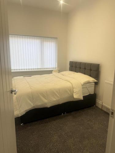 a bedroom with a large bed with a window at Nest in Northumberland 2 in Blythe