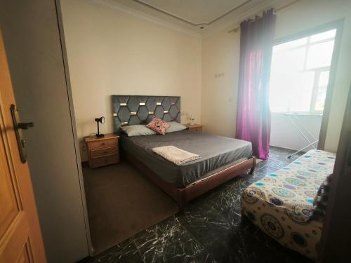 a bedroom with a bed and a window at Younes residence in Asilah