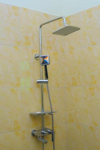 a shower with a shower head on a wall at standalone in Fort Portal