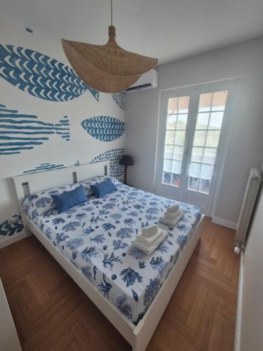 a bedroom with a bed with a blue and white comforter at Blu Marine Loano -Terrazza Vista Mare- in Loano