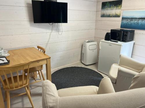 ein Wohnzimmer mit einem Tisch und einem Fernseher in der Unterkunft Salvos in Keitelepohja