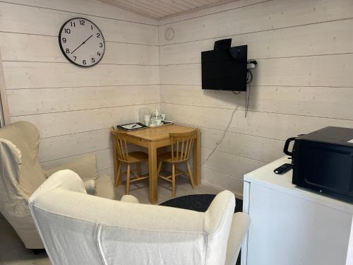ein Zimmer mit einem Tisch und einer Uhr an der Wand in der Unterkunft Salvos in Keitelepohja