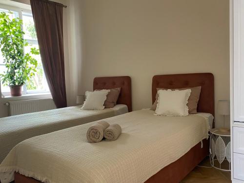 two beds with towels on top of them in a bedroom at Patak & Stone apartman in Szentendre