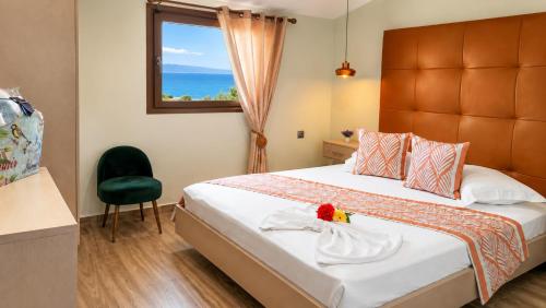 a bedroom with a bed with a window and a chair at Sea breeze 2 in Limenaria