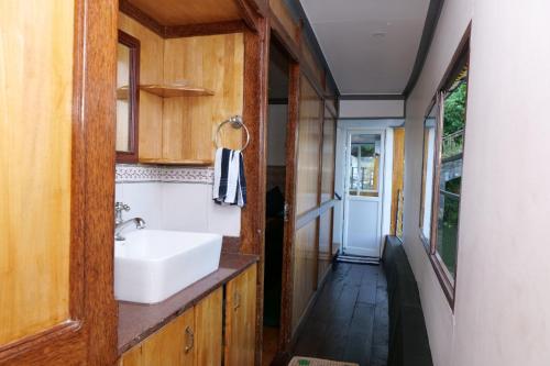 a bathroom with a white sink and a hallway at Marari houseboat in Mararikulam