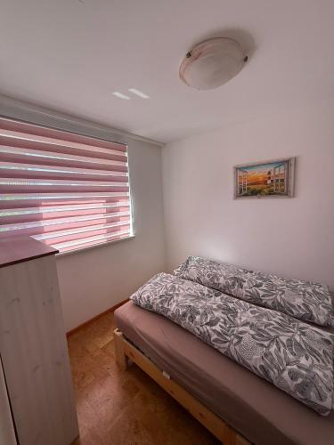 a small bedroom with a bed and a window at Ferienwohnung am Gothewanderweg in Schwarza