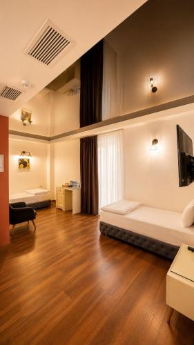 a room with two beds and a flat screen tv at Wald Hotel Lagodekhi in Lagodekhi
