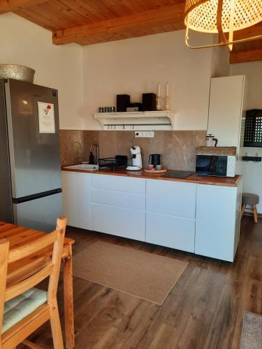 a kitchen with white cabinets and a refrigerator at Vulcanus Apartment in Badacsonytomaj
