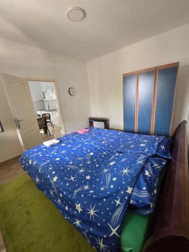 a bedroom with a blue comforter on a bed at Nin Apartman Free Parking in Kaluđerica