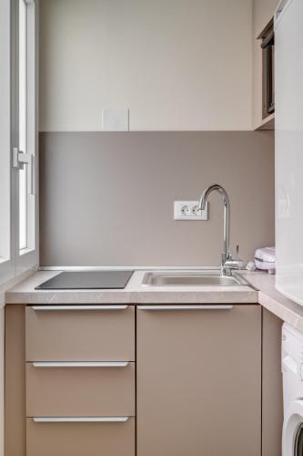 a white kitchen with a sink and a window at Syranna in Ermoupoli