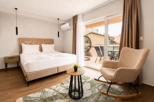 a bedroom with a bed and a chair and a balcony at Apartments Ilija in Ohrid