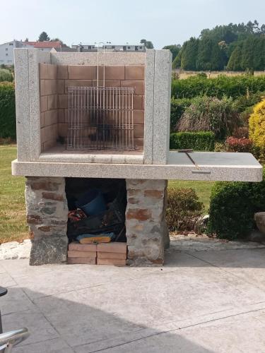 a stone fireplace with a bird in a cage at Toxiños Lavacolla in A Coruña