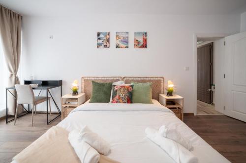 a bedroom with a large white bed and two tables at Central Summer Theatre Suites in Veliko Tŭrnovo