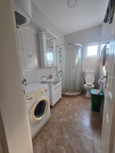 a bathroom with a washing machine and a toilet at Nin Apartman Free Parking in Kaluđerica