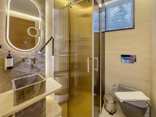 a bathroom with a shower with a sink and a toilet at The ABC Hotel in Alaçatı